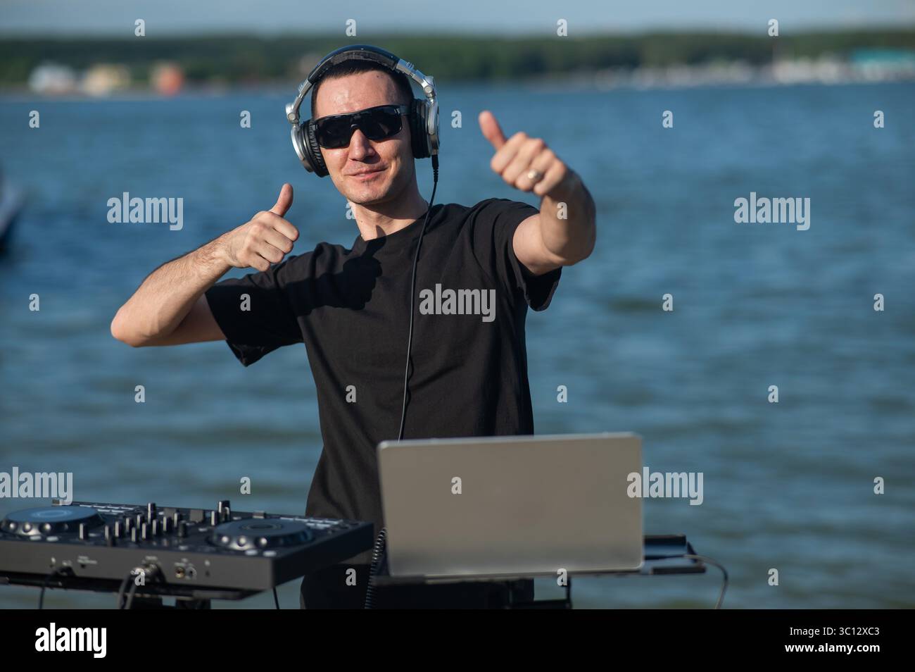 Kaukasier arbeitet als DJ am Strand. Stockfoto
