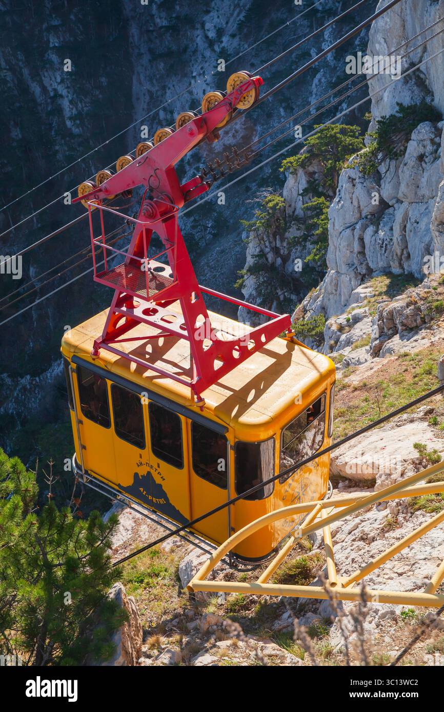 Ai-Petri, Krim - 29. Oktober 2018: Gelbe Kabine einer Seilbahn führt an einem sonnigen Tag zum Ai-Petri Berg, vertikales Foto Stockfoto