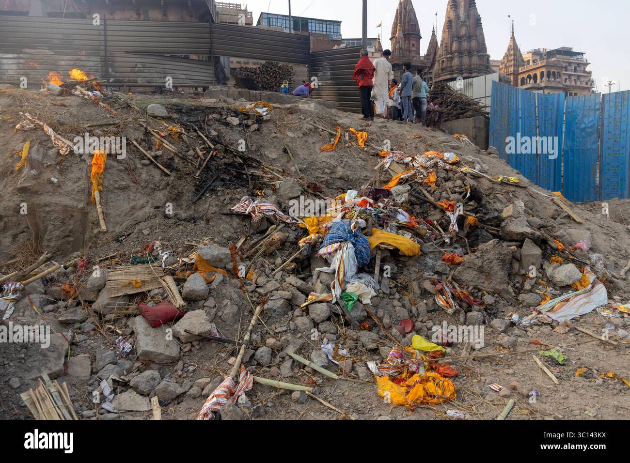 Beerdigungstraditionen und Verschmutzung in Manikarnika Ghat, Indien, verstreute Beerdigungsverpackungen, Bambusbänke und Asche liegen am 6. Juni 2025 entlang der Einäscherungsstelle in Manikarnika Ghat am Ufer des Ganges in Varanasi, Indien. Manikarnika Ghat in Varanasi ist der heiligste Einäscherungsgrund des Hinduismus, ein ergreifendes Tor zur Befreiung. Sie glauben, dass sie Moksha-Rettung direkt gewähren, und unzählige Gläubige bringen ihre Verstorbenen hierher, um sich aus dem Zyklus der Wiedergeburt zu befreien. Diese tiefgreifende spirituelle Praxis hat jedoch eine hohe Umweltbelastung. Die kontinuierlichen Scheiterhaufen kontra Stockfoto