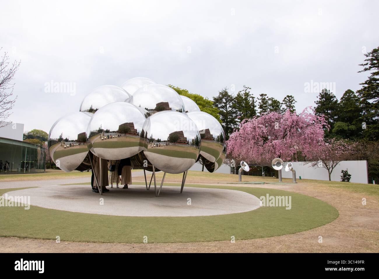 Kanazawa Japan Sakura Kirschbäume Parks Menschen Blumen blühen 21. Jahrhundert Museum für zeitgenössische Kunst Reflexionen auf Edelstahl Spiegel Stockfoto