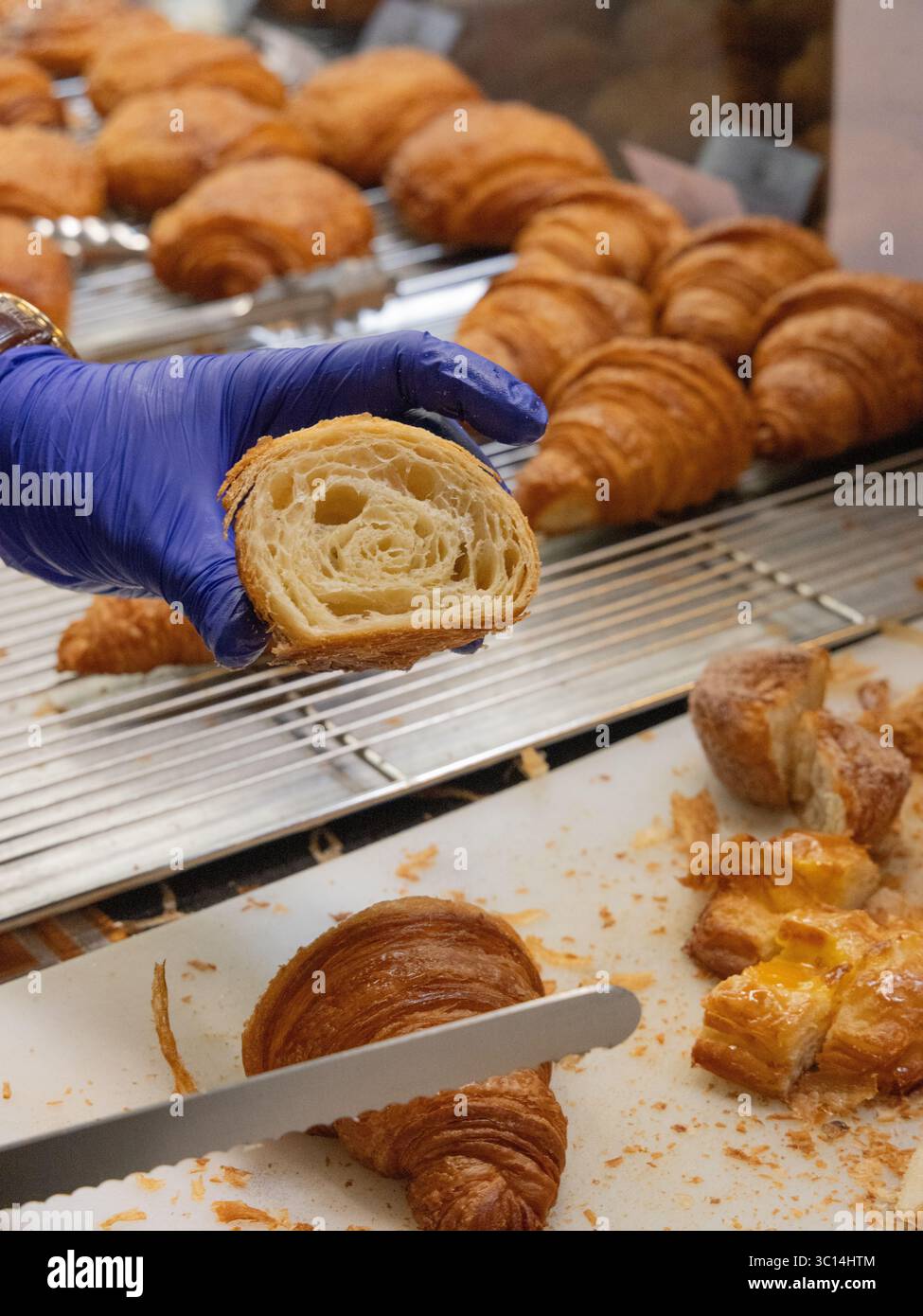 National Geographic Traveller Food Festival Sweet Dough Things Stand GB33 zeigt geschnittene Croissants zur Hälfte und Messer zum Schneiden von Croissants Stockfoto