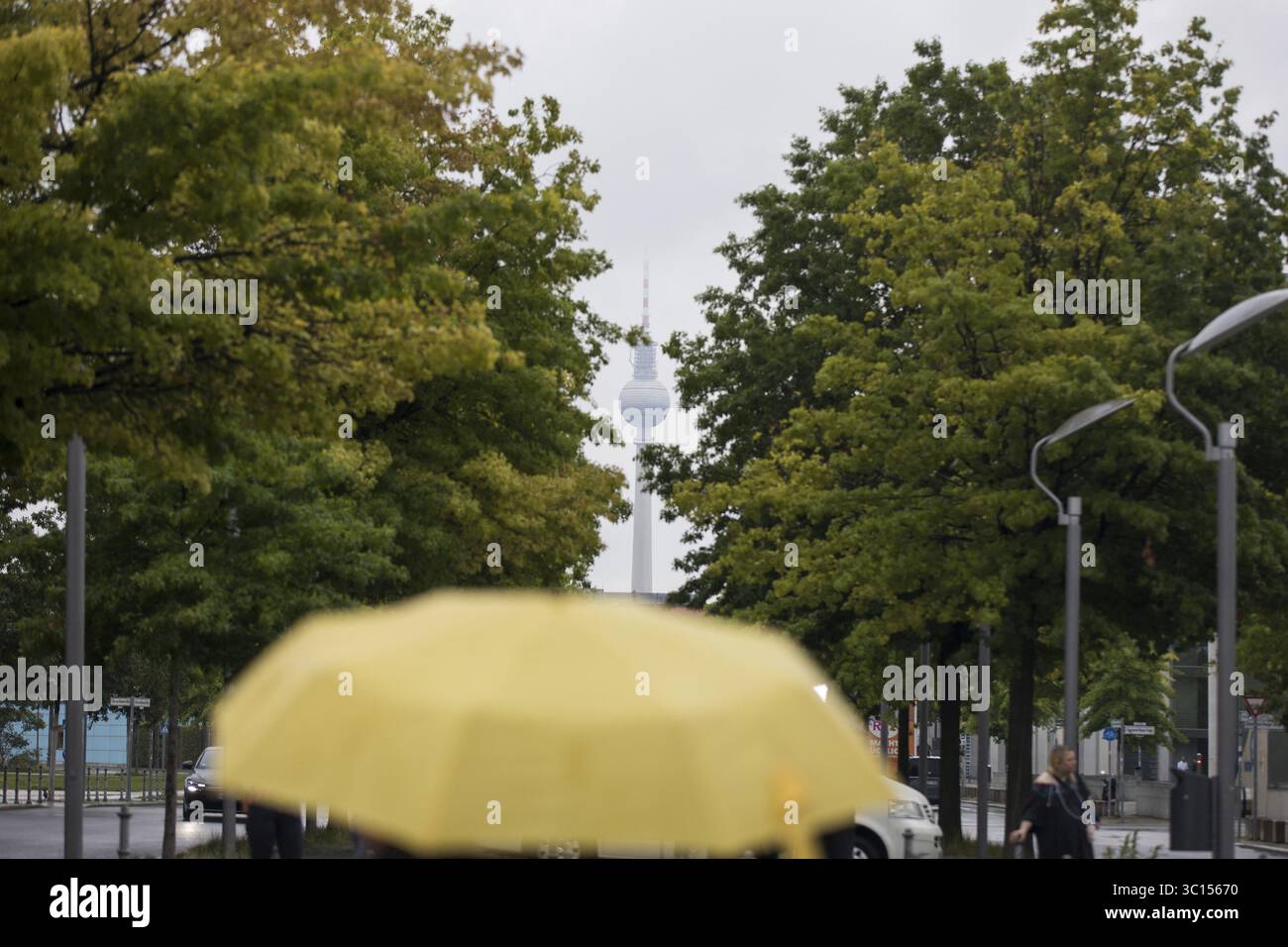Menschen laufen mit Sonnenschirmen durch den Regierungsbezirk in Berlin, 21.07.2025 Stockfoto