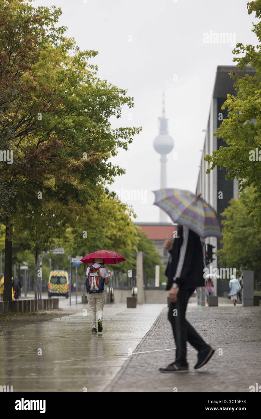 Menschen laufen mit Sonnenschirmen durch den Regierungsbezirk in Berlin, 21.07.2025 Stockfoto