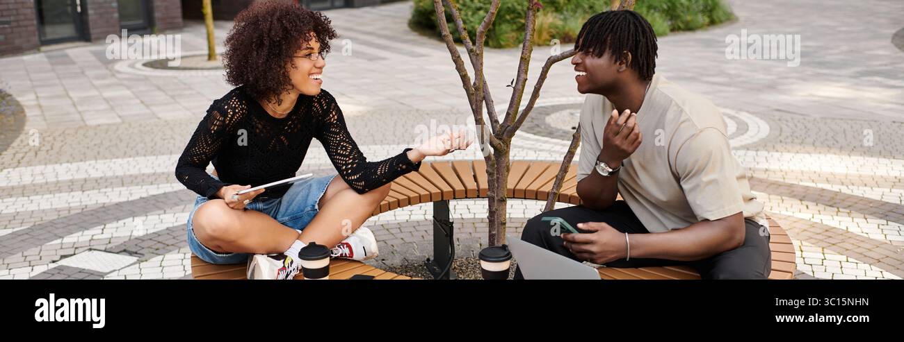 Stilvolles junges Paar arbeitet fernab zusammen in einer lebhaften Stadtatmosphäre, Banner Stockfoto