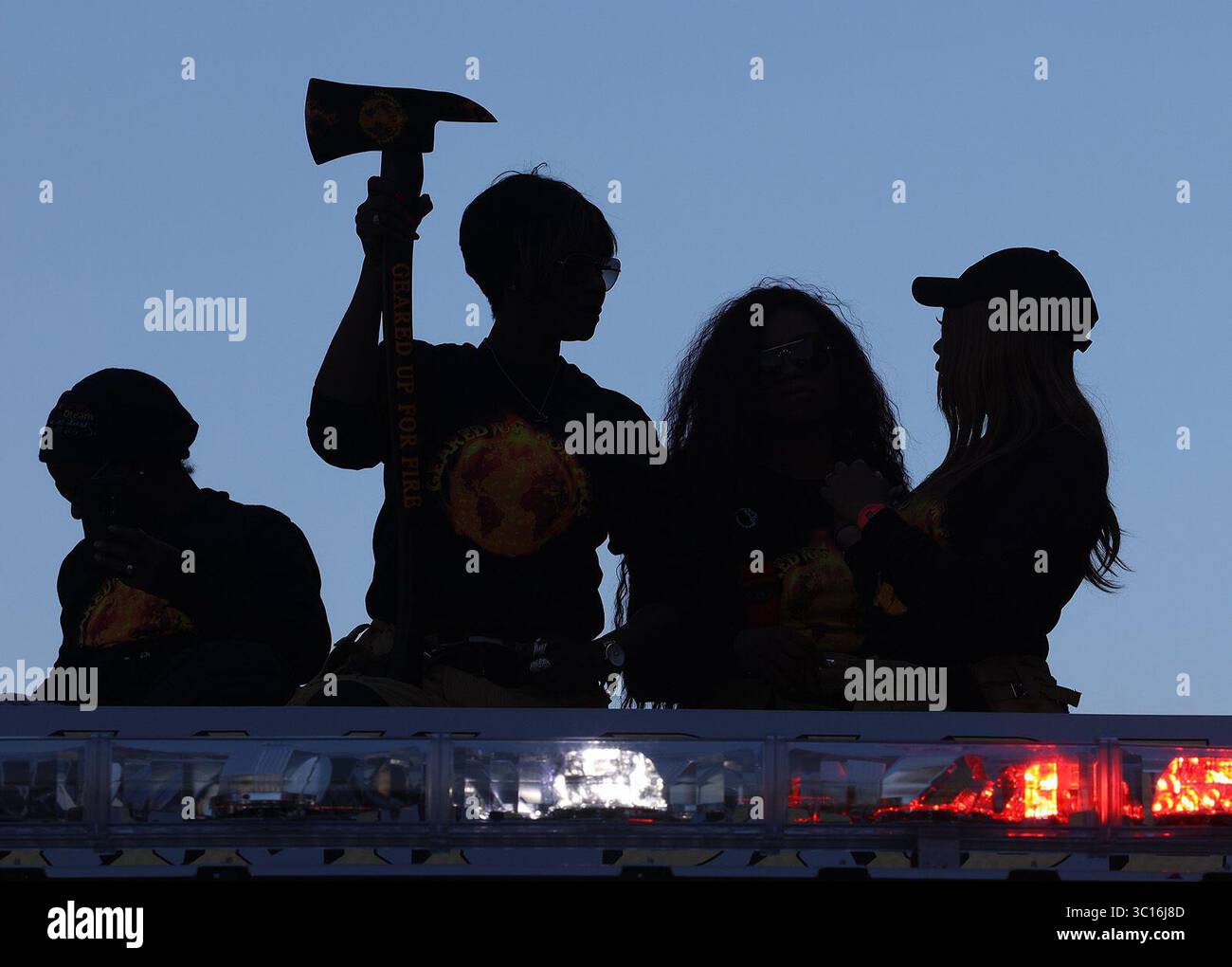 21. Januar 2019 - Miami, FL, USA - die Damen der Farben von Miami-Dade Fire & Rescue stehen auf einem Feuerwehrauto, während ihre Silhouetten während der MLK Day Parade in Liberty City am Montag, den 21. Januar 2019 gegen den klaren blauen Himmel geworfen werden. Die jährliche Parade zeigt marschierende Bands, Gastronomiebetriebe, Musik und vieles mehr, während Miamis Stadtviertel Liberty City das Erbe von Martin Luther King Jr. feiert (Credit Image: © Carl Juste/Miami Herald/TNS via ZUMA Wire) Stockfoto