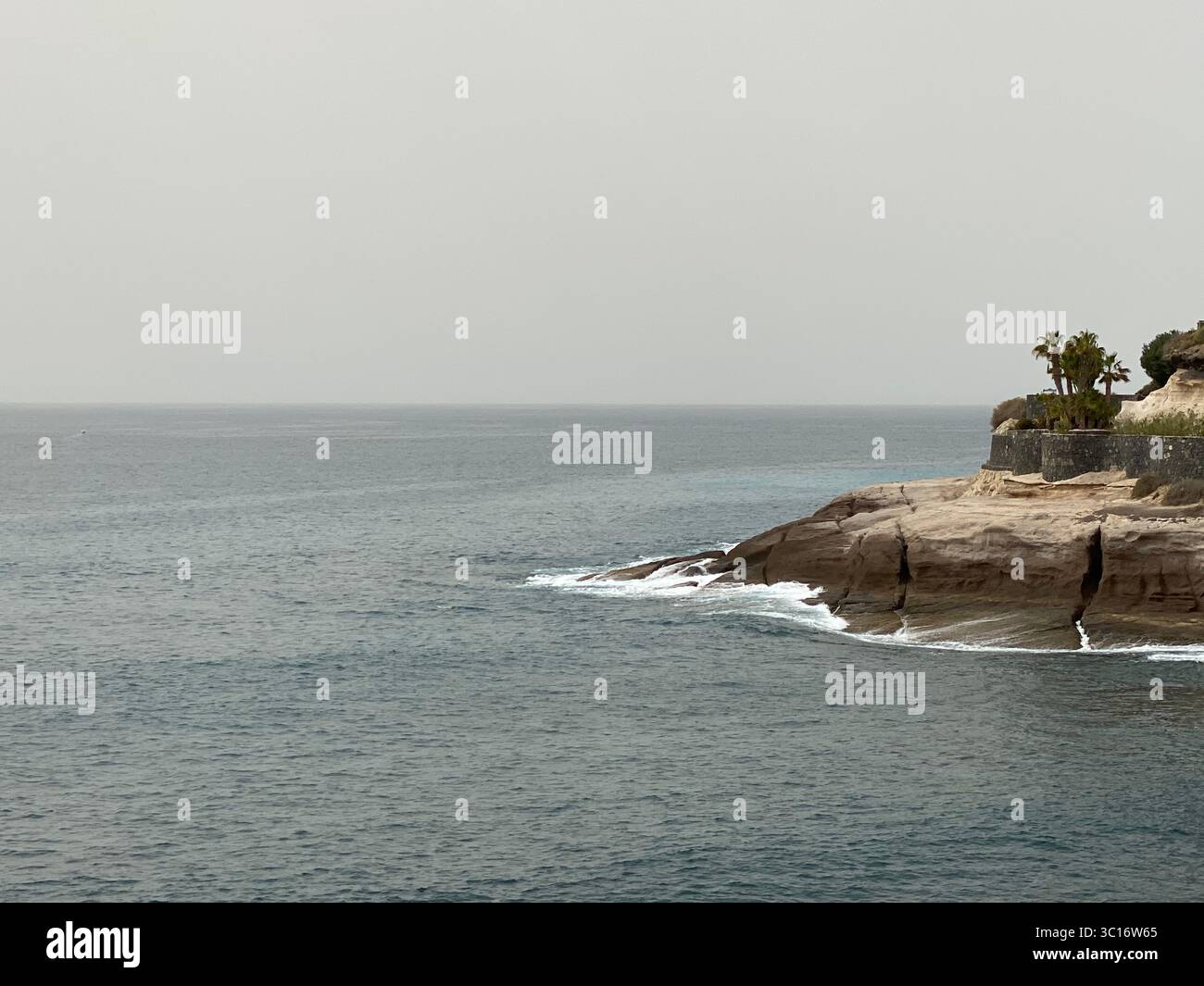 Malerischer Blick auf die Küste, auf der Insel Teneriffa, einer der Kanarischen Inseln, auf die Wellen des Ozeans gegen eine felsige Klippe stürzen - Smartphone-aufgenommenes Stockfoto