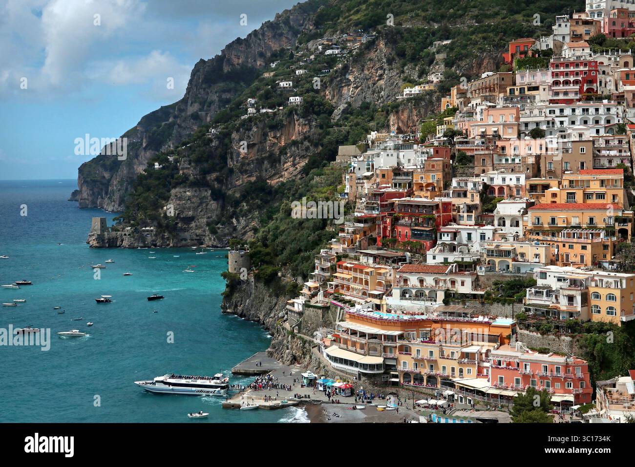 Weite Aufnahme: Bunte Häuser an den Klippen von Positano, die hinunter zum Fährhafen und dem Mittelmeer unten kaskadieren. Amalfiküste, Italien Stockfoto Weite Aufnahme: Bunte Häuser an den Klippen von Positano, die hinunter zum Fährhafen und dem Mittelmeer unten kaskadieren. Amalfiküste, Italien Stockfoto
