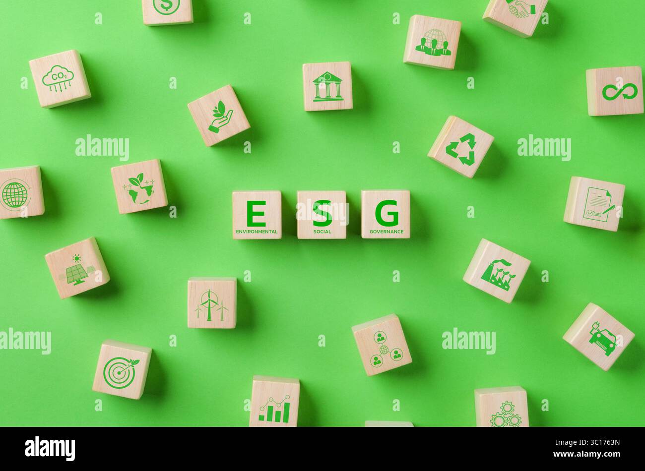 ESG-Investitionskonzept für umweltbezogene soziale Governance. Holzwürfel mit ESG Wort- und Umgebungssymbolen auf grünem Hintergrund. Umweltfreundliches Geschäft Stockfoto