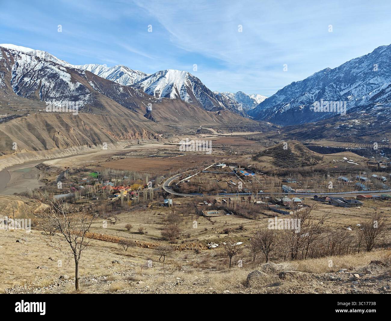 Atemberaubende Berglandschaft mit schneebedeckten Gipfeln, einem ruhigen Tal und einem klaren Himmel, die die Schönheit der Natur veranschaulichen Stockfoto