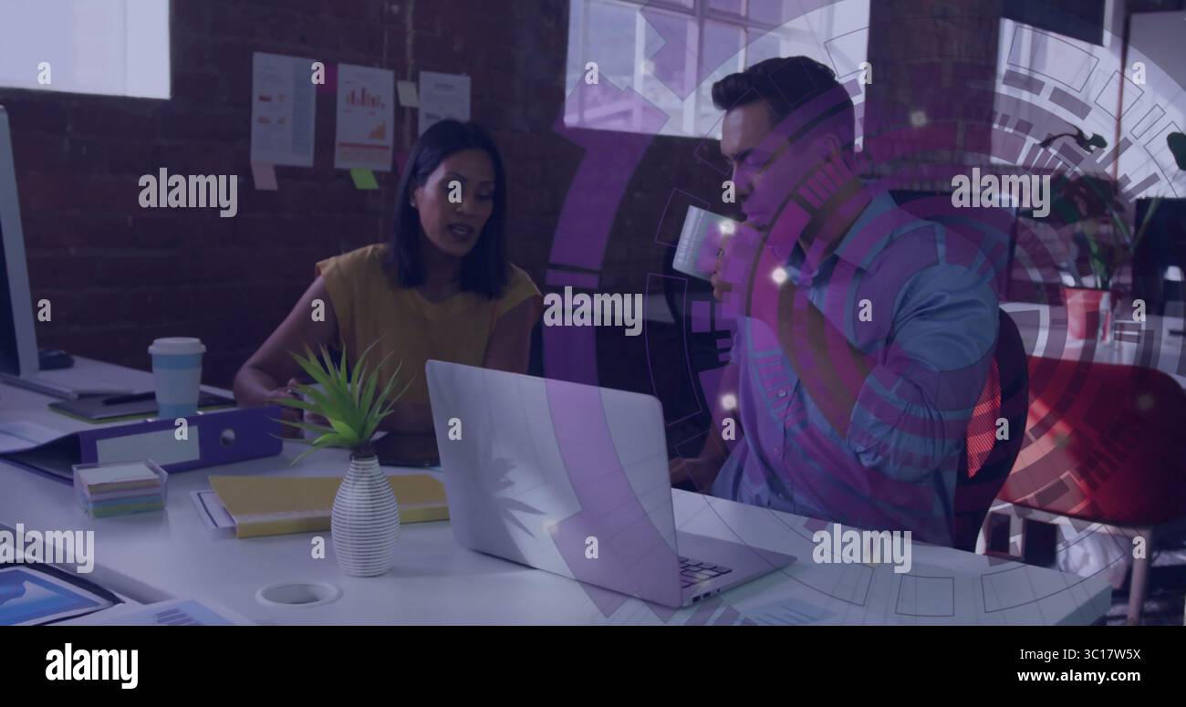 Kollegen, die im Büro Daten auf einem Laptop mit Kaffeetasse und Papieren überprüfen Stockfoto