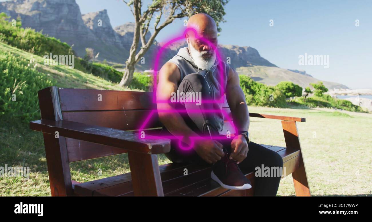 Schnürsenkel an Laufschuhen binden afroamerikanischer Mann, der sich auf eine Bank im Graspark stützt, mit Ohrstöpseln Stockfoto