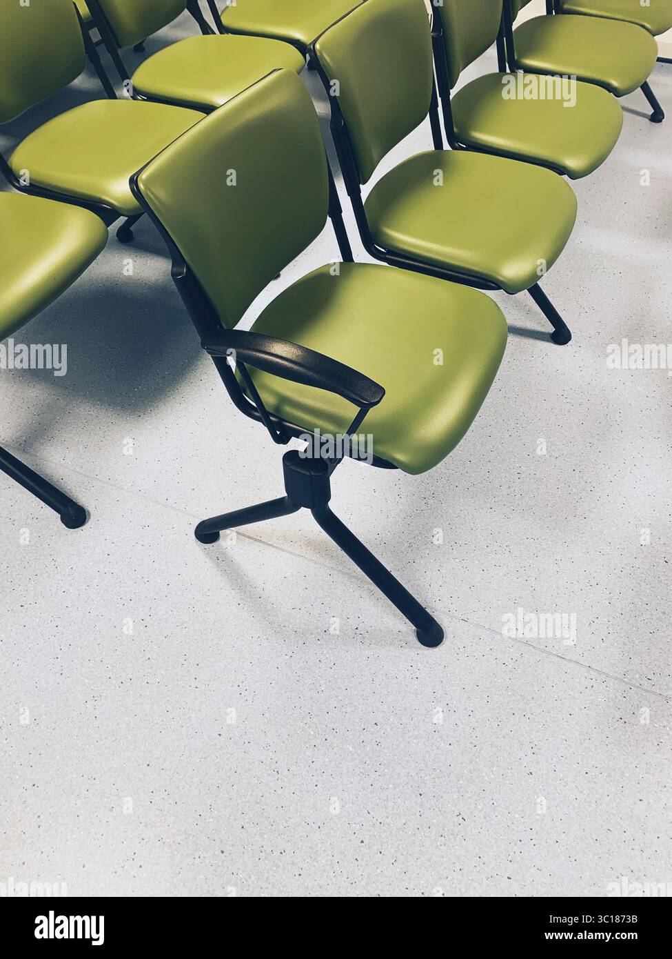 Leere Reihen grüner Sitzplätze im Wartezimmer – Stühle warten auf Bürostuhl Stockfoto