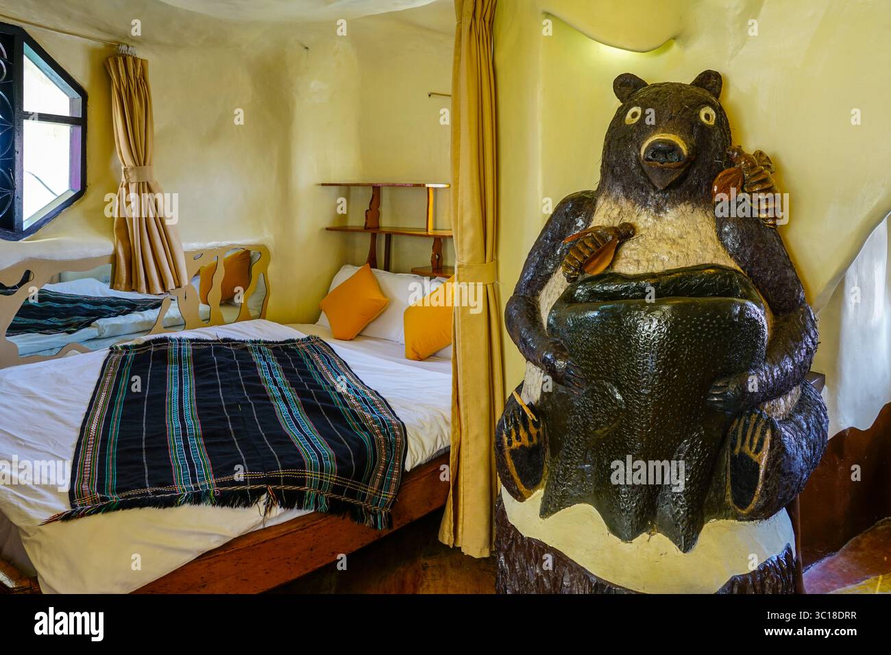 Da Lat, Vietnam - 24. März 2025: Ein gemütliches Gästezimmer im da Lat Crazy House mit einer skurrilen Bärenskulptur und einer von der Natur inspirierten Inneneinrichtung Stockfoto
