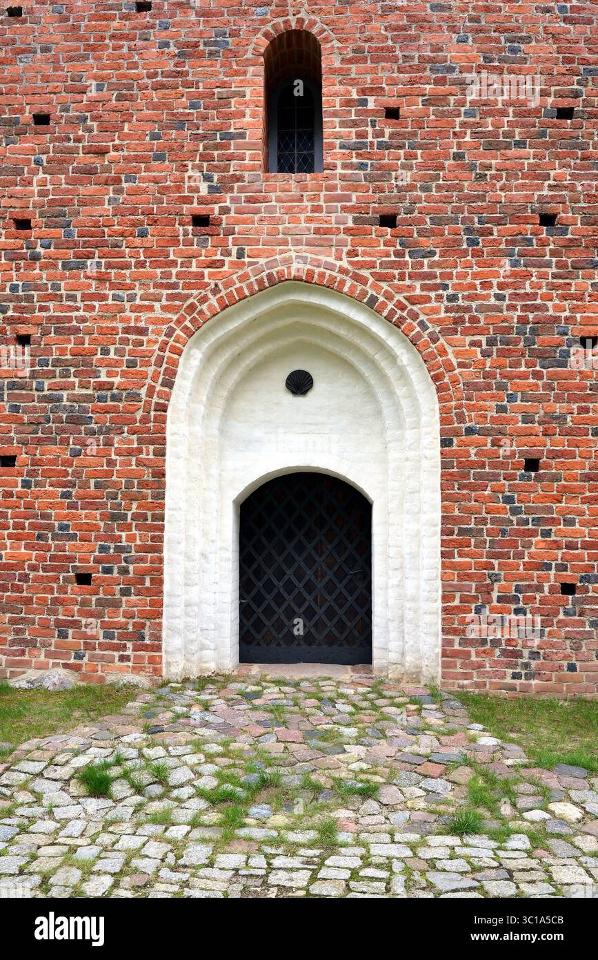 Historisches Spitzbogenportal mit Schalenrelief und Gittertür Stockfoto