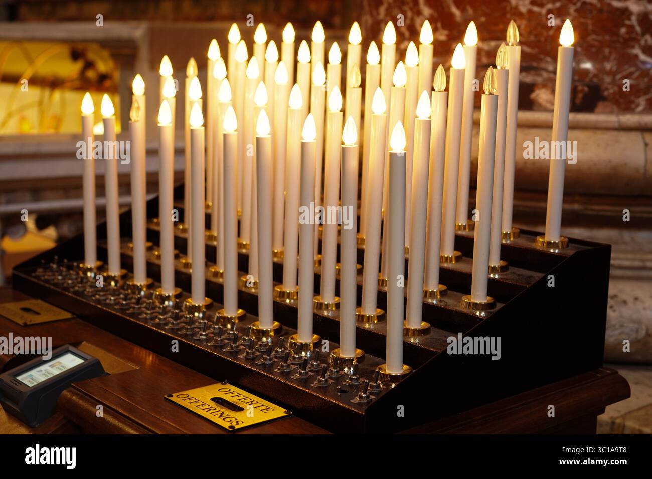 Kirchenkerzen beleuchtet mit Opfergaben Stockfoto