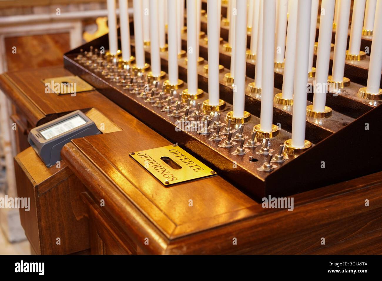 Kirchenkerzen beleuchtet mit Opfergaben Stockfoto