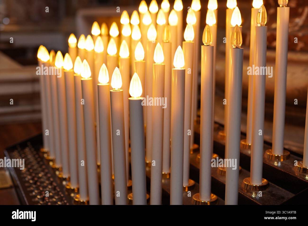 Kirchenkerzen beleuchtet mit Opfergaben Stockfoto
