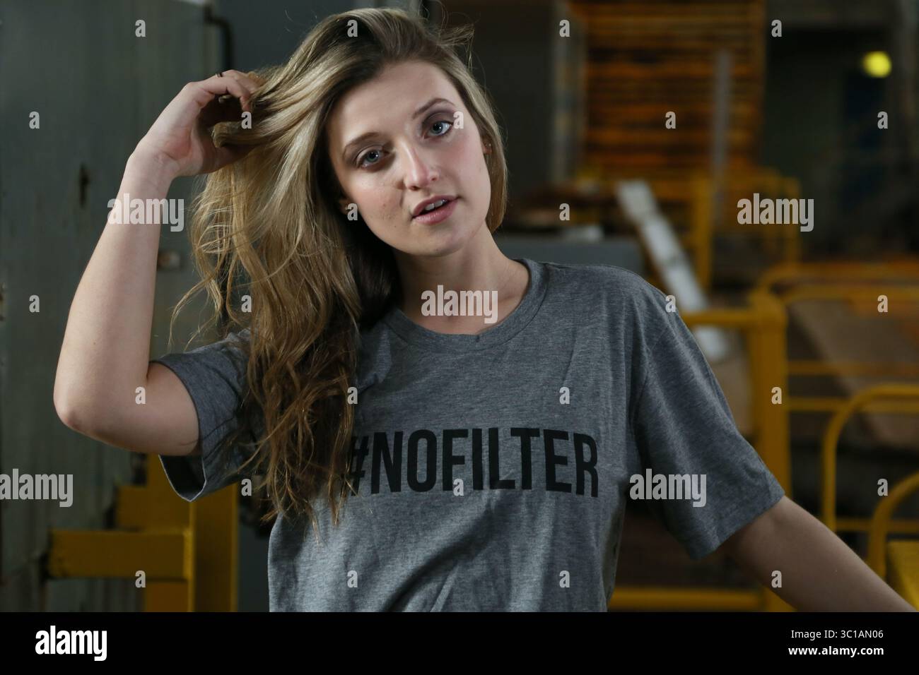 Weibliches Model mit #NOFILTER T-Shirt in einem Pumpenhaus am Shoreham Port Stockfoto