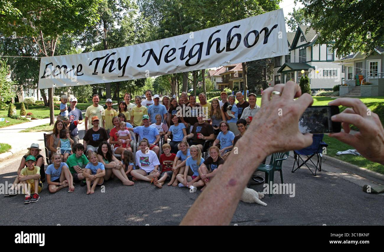 28. Juli 2012 – US-Bürger und Alumni des Blocks 5000 der Aldrich Ave. South in Minneapolis, versammelte sich für ein Gruppenfoto unter dem „Love Thy Neighbor“-Banner, das jedes Jahr für die Blockparty aufgeht. Die diesjährige Aldrich Block Party fand am 28/12 statt und zeigte ein Rückspiel einer Herausforderung, die vor 40 Jahren gegen den Block 5100 von Aldrich zu einem Volleyballspiel gemacht wurde. Der 5000er Block von Aldrich gewann das Volleyball-Rückspiel, das auf dem Block stattfand. Die 5000 Aldrich Ave. South hielt 1969 seine erste Blockparty ab. /Star Tribune.com (Credit Image: Bruce Bisping/Minneapolis Star Tribune/ Stockfoto