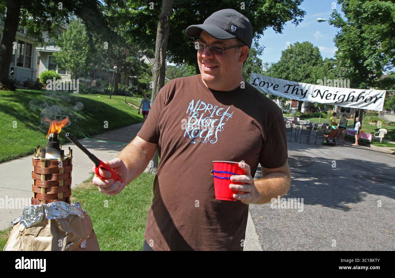 28. Juli 2012 – USA: Paul Daggett ließ den 5000er Block der Aldrich Ave. South Block Party ''olympische Fackel'', die ausgefallen war. Jedes Jahr hat die Blockparty ein Thema und dieses Jahr war es Sports!, Sports! Sport! Bewohner und Alumni des 5000 Blocks der Aldrich Ave. Im Süden von Minneapolis versammelte sich das Banner „Love Thy Neighbor“, das jedes Jahr für die Blockparty aufgehängt wird. Die erste Blockparty fand 1969 statt und die diesjährige Party fand am 28.07.12. Statt. Es gab ein Rückspiel einer Herausforderung, die vor 40 Jahren gegen den 5100er Block von Aldrich zu einem Volleyballspiel gemacht wurde. Die 500 Stockfoto