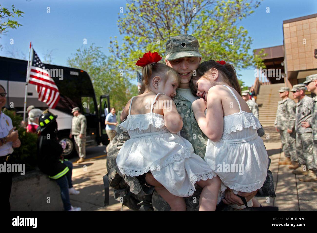 Mai 2012 - Brooklyn Park, MN, USA - Amelia Thompson, 3 links, und Madison Johnson, 4, begrüßte Forrest Thompson aus Roseville, MN, mit einem Kuss und einer Umarmung, nachdem er am Freitag, den 4. Mai 2012 in Brooklyn Park Armory angekommen war. Thompson war einer von mehr als 220 Soldaten des 1. Brigade Combat Teams der 34. Infanteriedivision, die am Freitag den ganzen Tag über zurückkehrte. "Die neunte Welle der Soldaten des 1. Brigade Combat Teams soll freitags morgens und nachmittags ankommen", sagte Armeeoberst Rick T. Schute, Offizier des 1. Brigade Combat Teams, 34. Red Bull Infantry Divisi Stockfoto