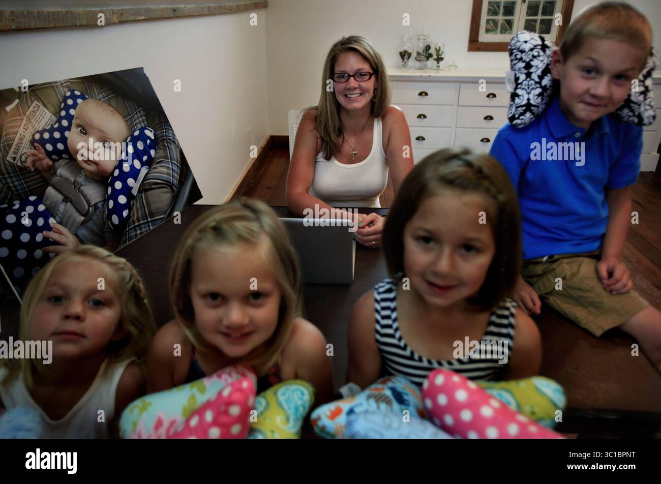 10. Juli 2012: Alicia Overby und ihre Kinder (von links nach rechts) Pearl (4 Jahre), Sylvi (5 Jahre), Lilly (8 Jahre alt) und Finn (6 Jahre alt) in ihrem neuen Büro in Cambridge, MN. Juli 2012. Alicia Overby, 763 670 1581 eine vierjährige Mutter, die vor weniger als zwei Jahren in ihrem Keller in Cambridge angefangen hat, ihre Baby Elephant Ears Kindersitzkissen zu nähen, erwartet, dass sie in diesem Jahr mehr als 2 Millionen Dollar davon verkaufen wird. Die Produktion wurde in ein Werk in Wisconsin verlegt, und Overby ist dabei, die Renovierung einer 150 Jahre alten Scheune abzuschließen, damit sie ihre Büros und Inventare aus ihrem Haus verlegen kann. Es ist der Stockfoto