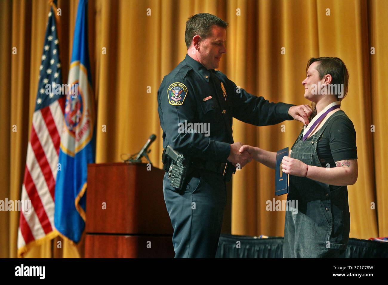 17. Mai 2012 – Bloomington, USA – der Polizeichef von Bloomington, Jeffrey D. Potts, überreichte Andrea Tokar während der Verleihung der Behavior Recognition Awards des Bloomington Police Department am Donnerstag, den 17. Mai 2012 eine Citizen Medal of Valor. Achtzehn Menschen wurden bei der Veranstaltung geehrt. (/STAR TRIBUNE) (Bild: Elizabeth Flores/Minneapolis Star Tribune/TNS via ZUMA Wire) Stockfoto