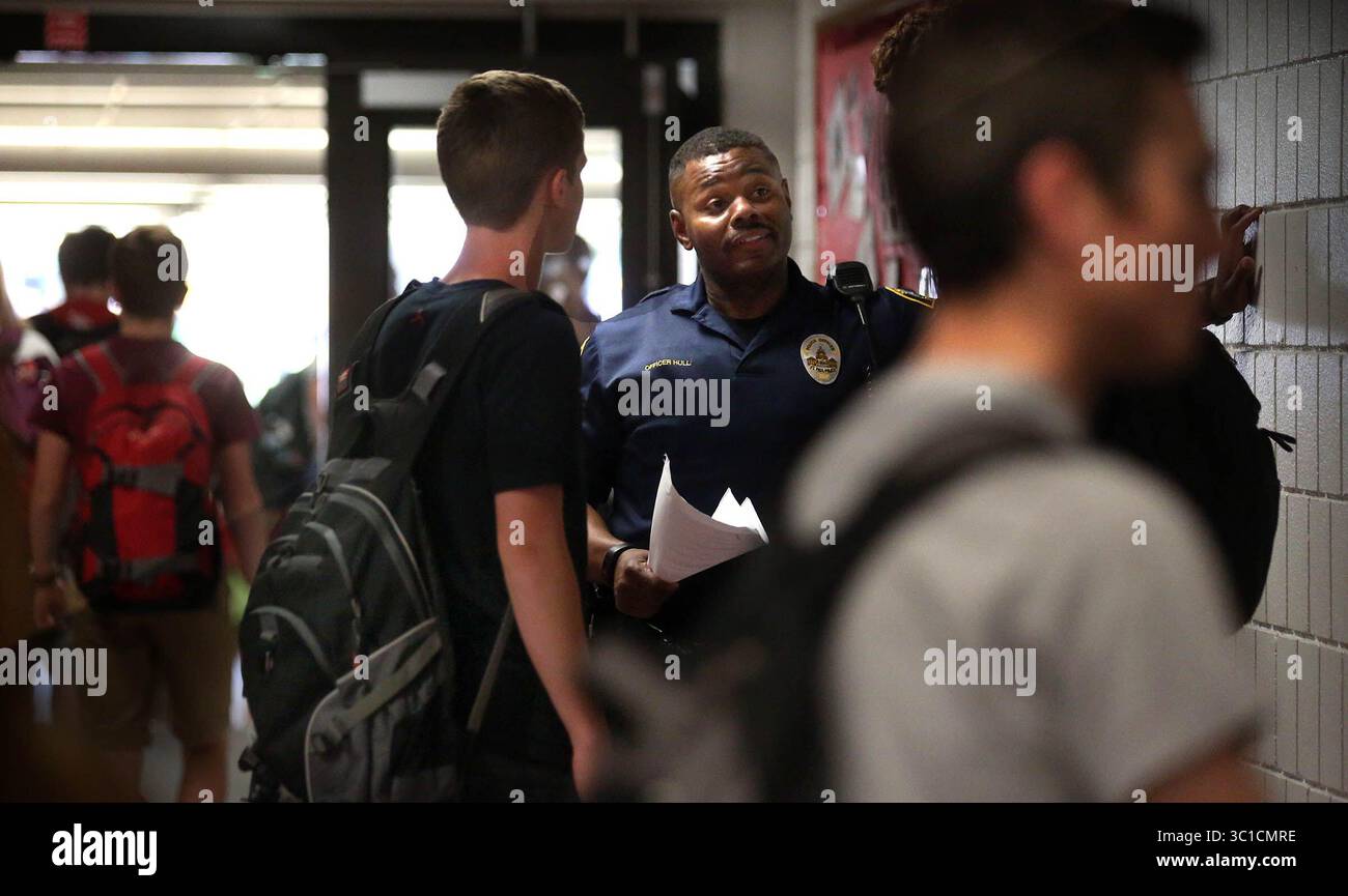 8. Juni 2016: St. Paul, MN, USA: Cortez Hull, Schulressourcenoffizier (SRO) an der Highland Park High School in St. Paul, interagierte am Ende der Schule mit Schülern. / St. Paul, MN / 8. Juni 2016 15:00 Uhr – HINTERGRUNDINFORMATIONEN: Die jüngsten Ereignisse haben scharfe Kontraste in der Art und Weise gebracht, wie Schulverantwortliche -- Polizisten in den Schulen -- vor Ort gesehen werden, und ihre Zukunft in zwei der größten Bezirke des Bundesstaates ist eine Frage, die jetzt diskutiert wird. In St. Paul ehrten die Bezirksführer Vernon Simmons, einen langjährigen SRO, der für seine beruhigende Präsenz an der Johnson High bekannt war, bei einem Treffen eine Woche lang Stockfoto