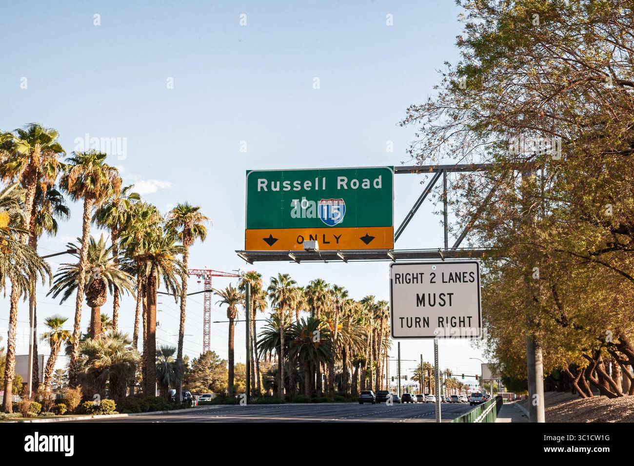 Die grüne Führungstafel über der Russell Road führt die Fahrer zur Interstate 15 (I-15) über einem palmengesäumten Boulevard in Las Vegas. Ein sekundäres Bedienfeld zeigt an Stockfoto