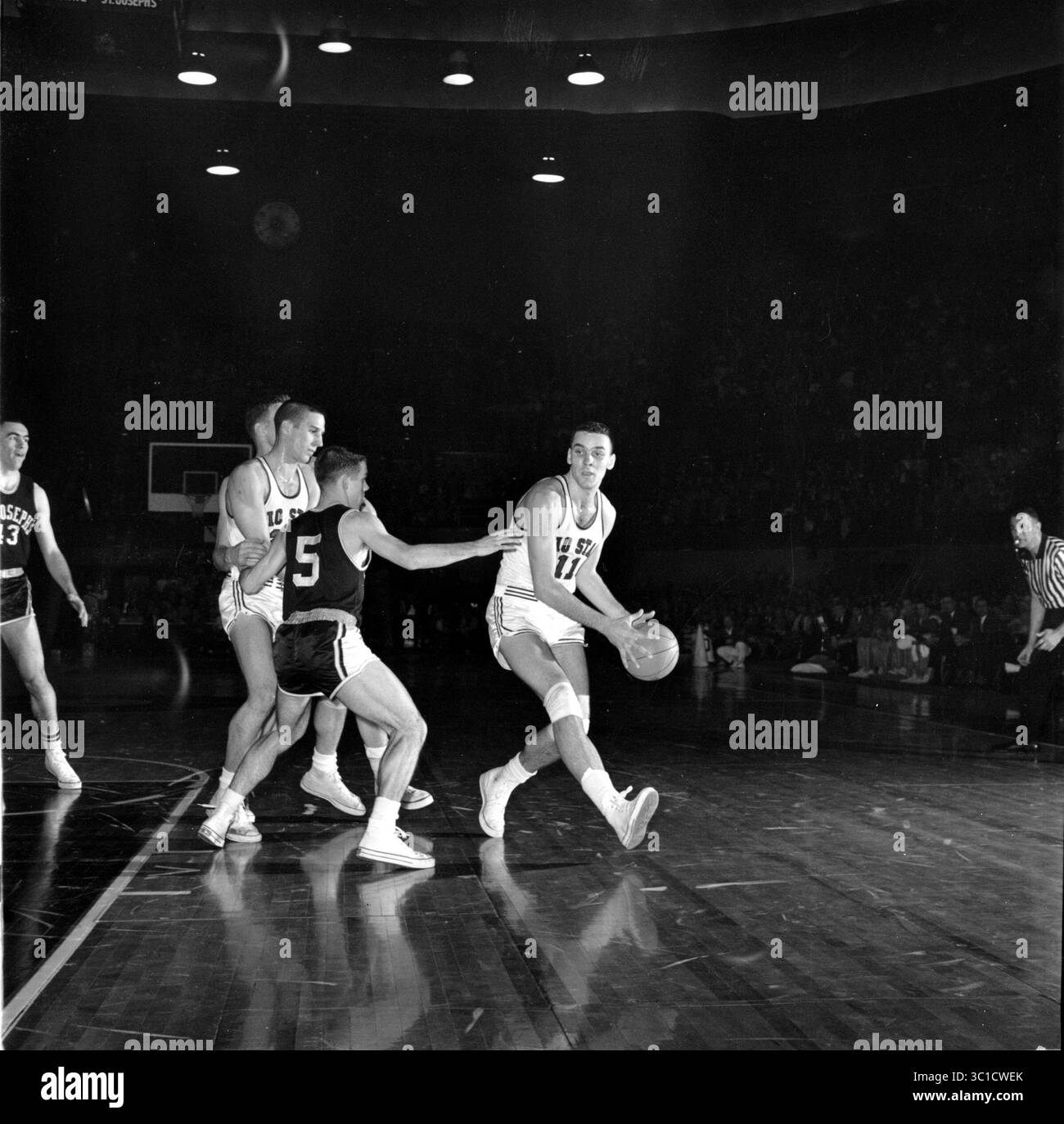 24. März 1961: Kansas City, USA: Jerry Lucas (11) des Bundesstaates Ohio (11) bricht in die Freizone ein, bevor er am 24. März 1961 im National Collegiate, NCAA, gegen St. Joseph's traf. Links ist St. Joseph's James Lynam (5) und hinter ihm Larry Siegfried. Ohio State gewann 95:69, und morgen wird Cincinnati für die Meisterschaft spielen. (Kreditbild: Minneapolis Star Tribune/TNS via ZUMA Wire) Stockfoto