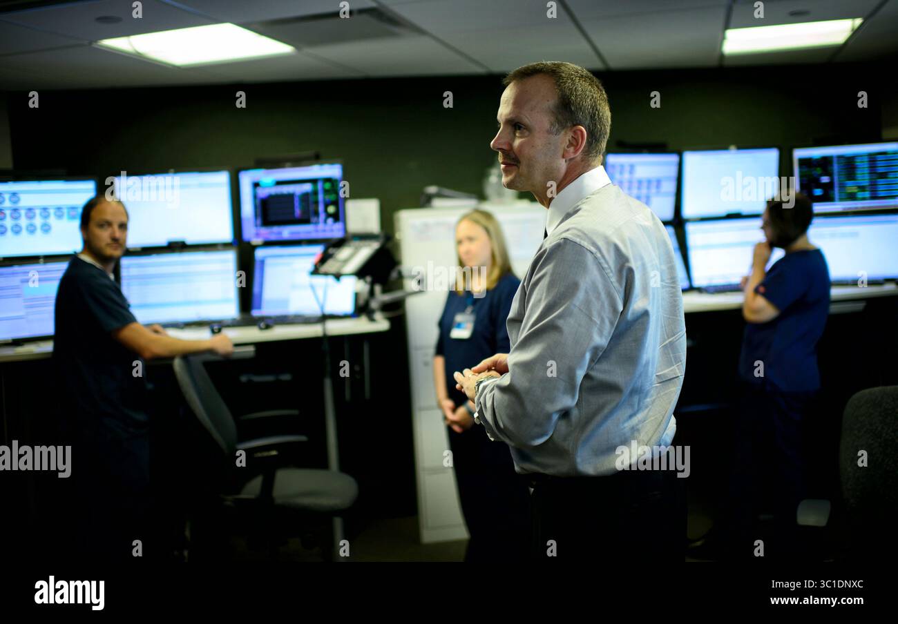 16. Juni 2015 - Rochester, Minnesota, USA - derzeit überwacht die Mayo EICU, oder elektronische Intensivstation, 73 Intensivstationen im Mayo Clinic Health System im Süden von Minnesota und kleinen Teilen von Iowa und Wisconsin. Im Rahmen des Pilotprogramms soll im September auf 101 Betten erweitert werden. Dr. Daniel Brown, Zentrum, ist Direktor der Intensivmedizin für Mayo und der diensthabende Arzt auf der EICU. Dienstag, 16. Juni 2015 in einem Raum der Mayo Clinic sehen Ärzte TV-ähnliche Bildschirme, um die Versorgung von Patienten auf Intensivstationen Hunderte von Meilen entfernt zu leiten. In einem anderen Raum überwacht das Personal das Blut Stockfoto