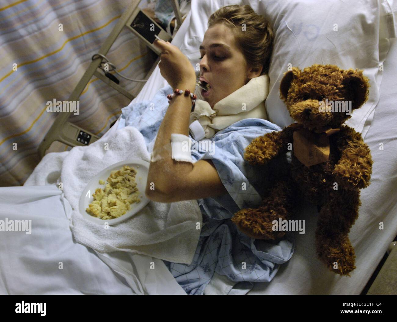 08. Januar 2005 – Toronto, ON, KANADA – CAITLIN BURK, 18, ernährt sich mit ihrer linken Hand von einer in der Critical Care Unit (CRCU) am Sunnybrook and Women's College Hospital. Caitlins Pläne für das kommende Jahr wurden durchbrochen, da sie nun vor Monaten der Reha steht, um ihren rechten Arm wieder zu benutzen. Der Teddybär ist ein Geschenk von ihrem Vater. (Kreditbild: Rick Madonik/Minneapolis Star Tribune/TNS via ZUMA Wire) Stockfoto
