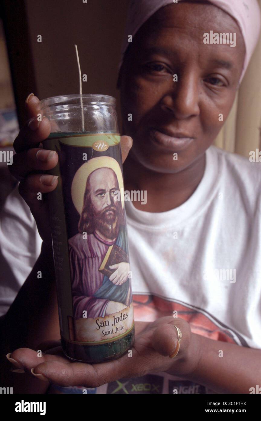September 2005; Montevideo, MN, USA; Tanya und Tracey Thornbury haben die Singleton-Familie aus New Orleans eingeladen, mit ihnen für ein Jahr zu leben. Der Singleton hat beim Hurrikan Katrina alles verloren. Dorothy Singleton und ihre Tochter Nicole und ihre 5 Kinder leben im 5-Schlafzimmer-Haus des Thornbury. Die Thornbury's haben 3 eigene Kinder, also leben 8 Kinder und 4 Erwachsene im Haus. In diesem Bild: Dorothy Singleton hält eine Votivkerze des heiligen Judas, der Schutzpatronin der verlorenen Sache ist. Das waren die einzigen wertvollen Dinge, die sie auf der Flucht vor Hurrikan mitbrachte Stockfoto