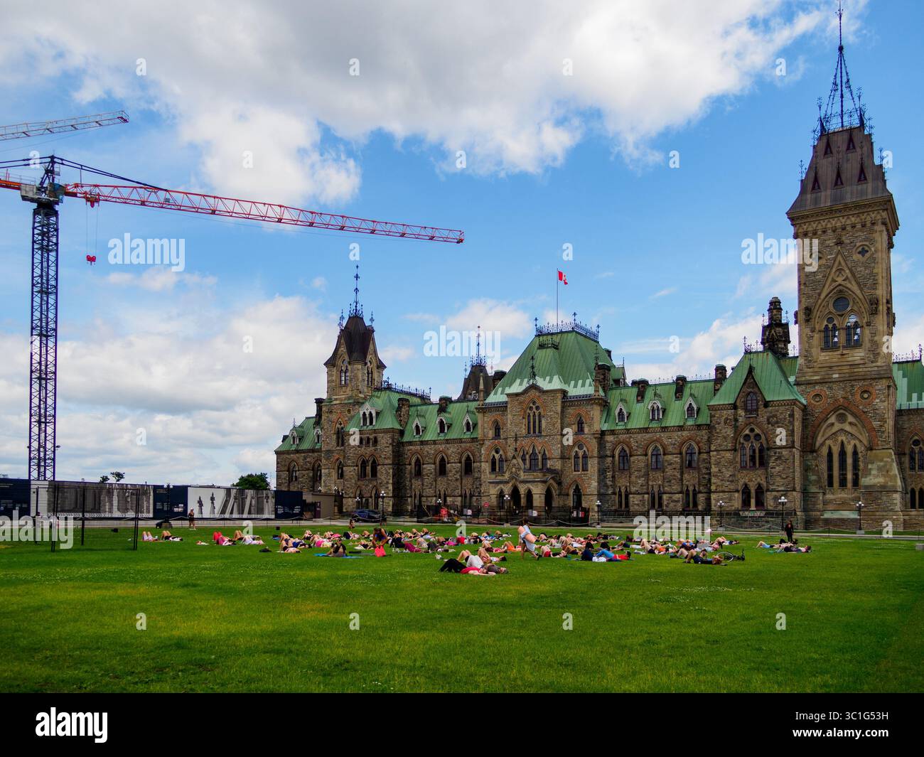Ansicht einer Gruppe von Personen, die Yoga auf dem Gras des Parlaments von Kanada (Hill Grass) neben dem East Block in Ottawa, Ontario, Kanada durchführen Stockfoto