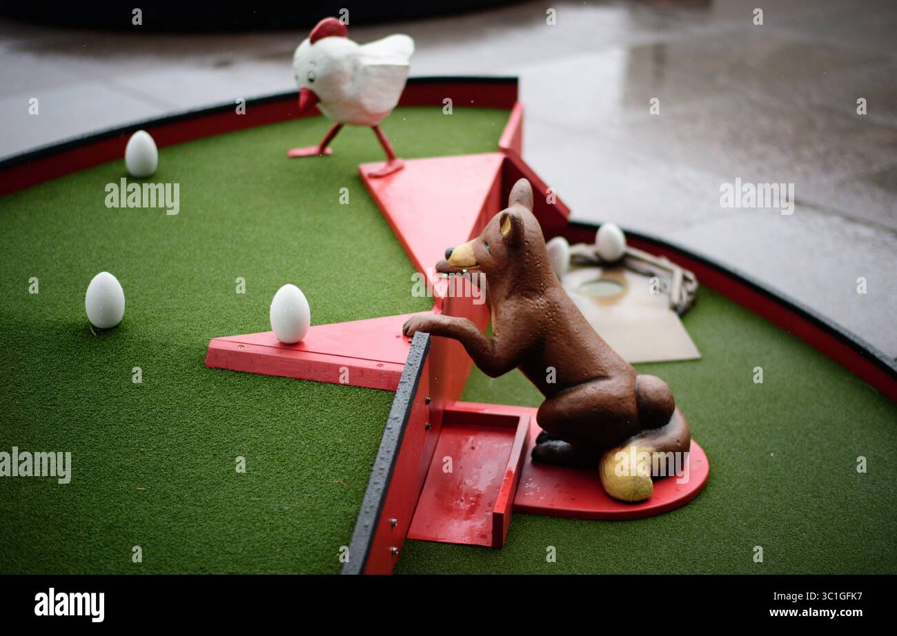 Mai 2016 - Minneapolis, Minnesota, USA - Loch 8. Raten Sie Mal, Was? Huhn Putt! Brian Fewell und Cami Applequist Brian Fewell und Cami ApplequistÕs Gute mal was? Huhn Putt! Es verfügt über ein eierförmiges Grün und ein mit Eiern gefülltes Hühnerstall-Labyrinth. Halten Sie sich vom Fuchs fern, der im Hühnerstall lauert, und führen Sie Ihren Ball sicher zum HenriettaÕs Nest, um diesen Mini-golfÊchallenge zu vervollständigen. Mittwoch, 25. Mai 2016 Wir fahren zum Walker Art Center, um Skyline Minigolf zu spielen - können wir eine gute Fahrt machen, ohne einen Ball durch ein Buntglasfenster zu werfen? Wir probieren den neuen Minigolfplatz im Walker aus. Stockfoto