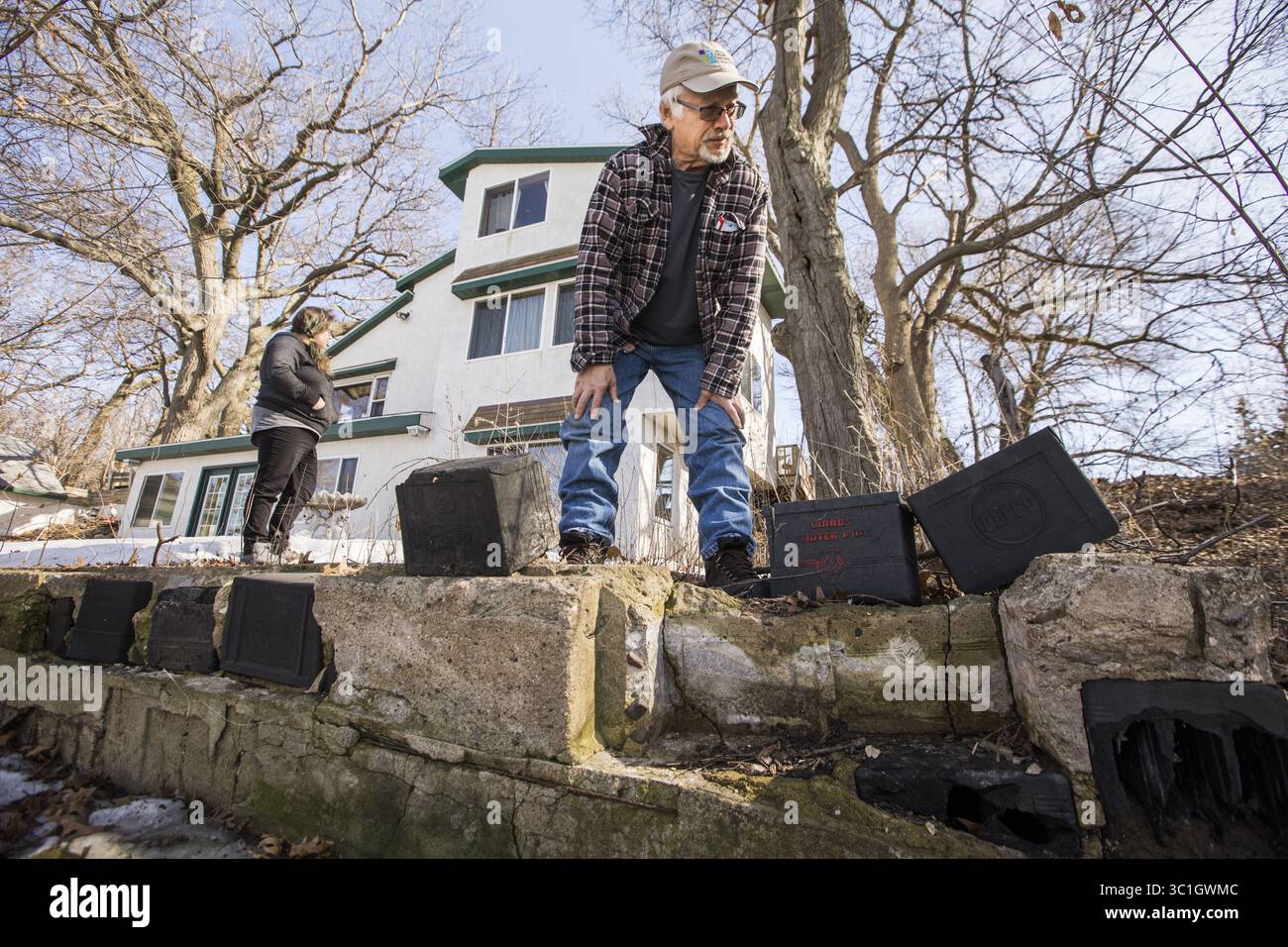 25. April 2018 – White Bear Lake, MN, USA – Bernie Brown betrachtet die Batteriegehäuse des Autos, die sich in der abbröckelnden Basis eines alten Gebäudes in der Nähe seines Hauses befinden. Das Fundament seines Hauses wurde auf die gleiche Weise gebaut. ...HINTERGRUNDINFORMATIONEN: Bernie Brown wusste, dass das alte, baufällige Anwesen am See in White Bear Lake ein großes Unterfangen sein würde, als er es 1993 kaufte. Die größte Eigenart? Das in den 1930er Jahren erbaute Haus hat ein Fundament aus Batteriegehäusen in zerbröckelndem Beton. Brown verbrachte Jahre und Hunderttausende von Dollar damit, das Anwesen zu reparieren, ohne es zu wissen, bis es wieder zurückkam Stockfoto