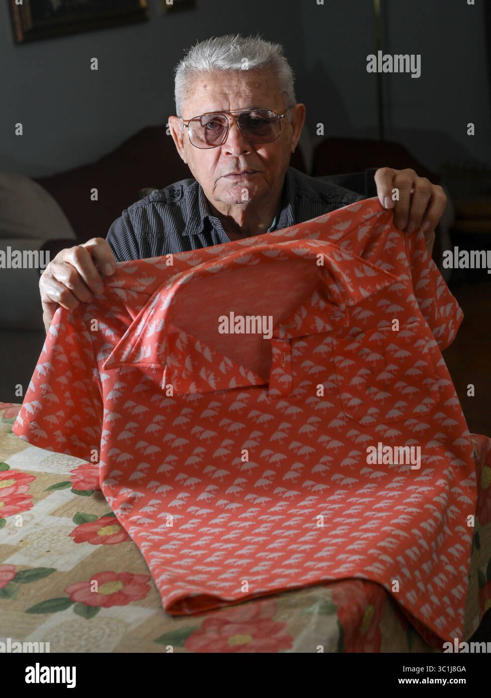 20. Februar 2019 - Tampa, Florida, USA - CHRIS URSO | Times. Roberto Pizano, 80, posiert am Mittwoch, 20. Februar 2019, für ein Foto mit einem 40 Jahre alten Hemd in seinem Haus in Tampa. Für seine Bemühungen, Fidel Castro in den Jahren nach der Machtübernahme zu stürzen, wurde Pizano in Kuba zu lebenslanger Haft verurteilt, gefoltert und in Arbeitslagern zur Arbeit gebracht. Am 21. Februar 1979 wurde Pizano nach 18 Jahren lebenslanger Haftstrafe freigelassen, zum Flughafen in Havanna eskortiert und nach Miami geflogen. (Foto: © Chris Urso/Tampa Bay Times via ZUMA Wire) Stockfoto