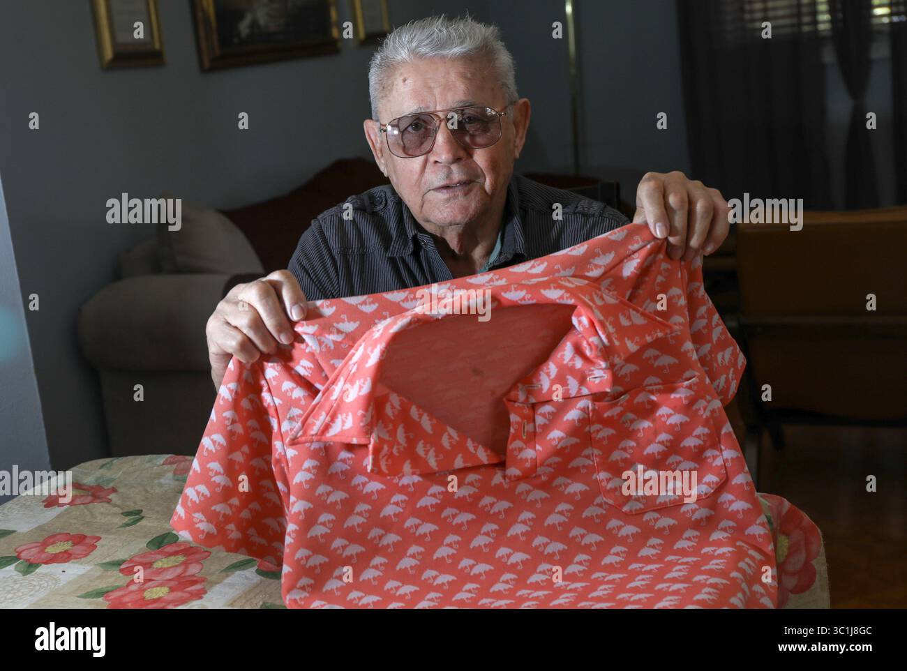 20. Februar 2019 - Tampa, Florida, USA - CHRIS URSO | Times. Roberto Pizano, 80, posiert am Mittwoch, 20. Februar 2019, für ein Foto mit einem 40 Jahre alten Hemd in seinem Haus in Tampa. Für seine Bemühungen, Fidel Castro in den Jahren nach der Machtübernahme zu stürzen, wurde Pizano in Kuba zu lebenslanger Haft verurteilt, gefoltert und in Arbeitslagern zur Arbeit gebracht. Am 21. Februar 1979 wurde Pizano nach 18 Jahren lebenslanger Haftstrafe freigelassen, zum Flughafen in Havanna eskortiert und nach Miami geflogen. (Foto: © Chris Urso/Tampa Bay Times via ZUMA Wire) Stockfoto