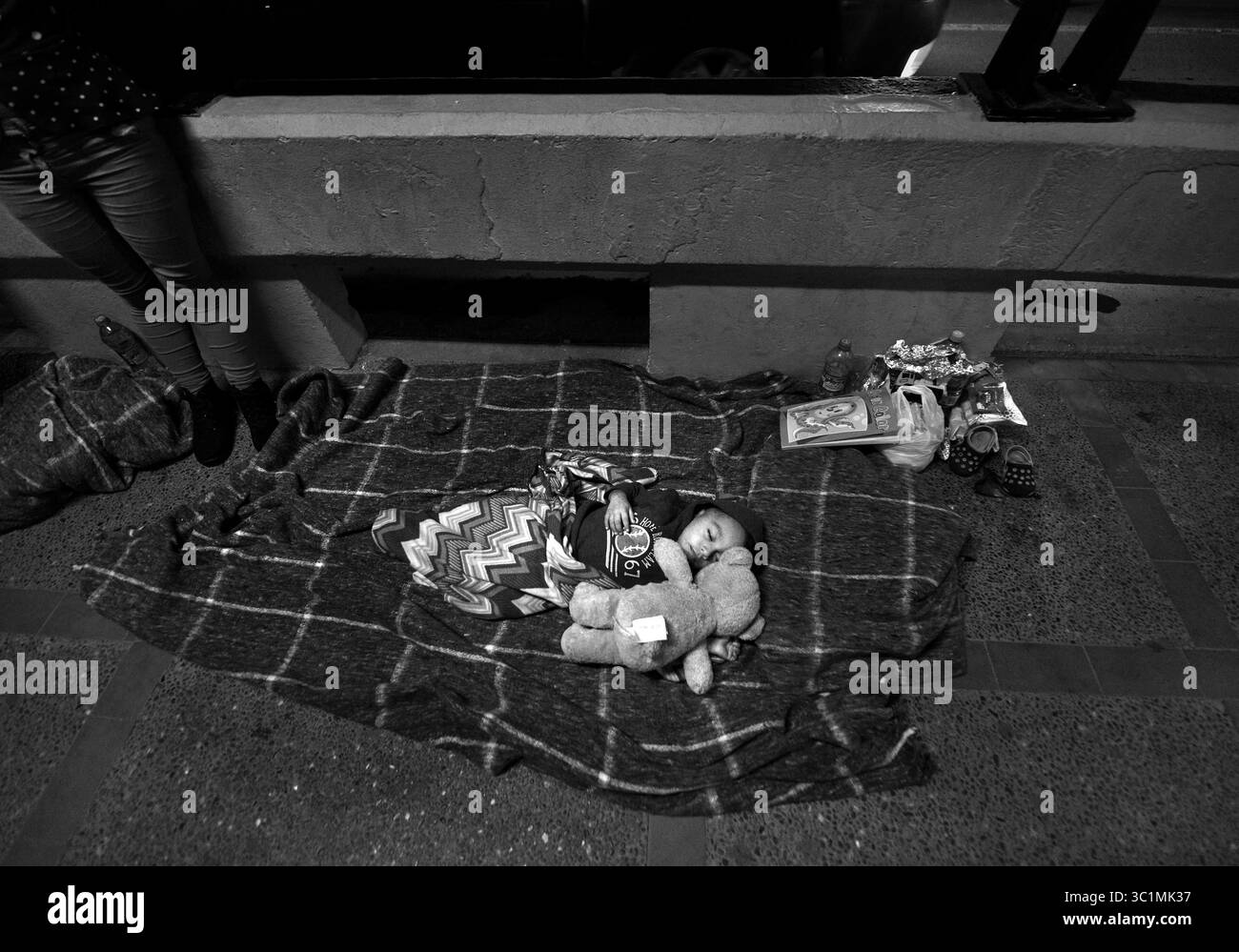 2. Juli 2018: Matamoros, Mexiko – Ingrid Perdomo, 18, und ihr einjähriger Sohn Jose Luis, schlafen mit anderen Asylsuchenden auf der Gateway International Bridge und warten darauf, von Mexiko aus in die USA zu überqueren. Sie kam mit ihrem Gefährten Luis Miguel, 32 Jahre alt, aus Honduras, wo sie die schwierige 3-monatige Reise machten. Er sagte, er floh vor Angst und weinte viel vor Angst über seine Vergangenheit. Seine Ex-Frau fing an, mit einem Bandenmitglied auszugehen, und die Gang zündete sein Haus an und tötete seine beiden Kinder darin. Er floh in die Berge, um Sicherheit zu suchen, wo er Ingrid traf und sie ein weiteres Kind hatten. Als sie das erste Mal ankamen, sagten sie es Stockfoto