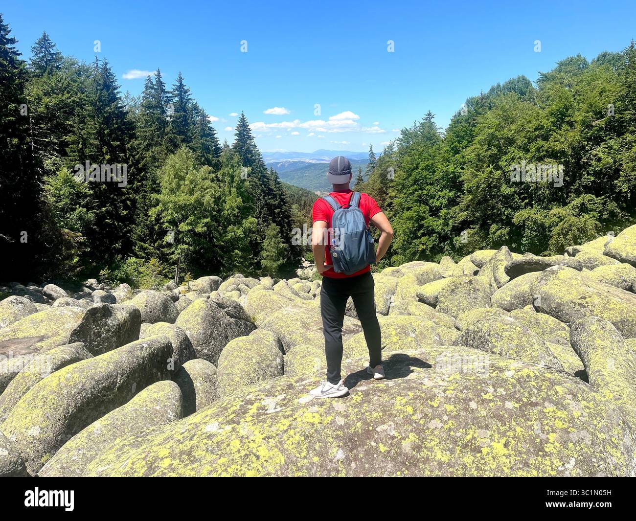 Männlicher Wanderer, der auf einem großen Felsbrocken am Steinfluss „Goldene Brücken“ im Vitosha-Gebirge, Sofia Bulgarien, Südosteuropa, Balkan, EU steht Stockfoto