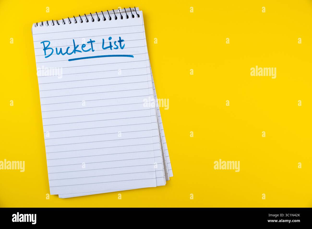 Löffelliste auf liniertem Notizblock isoliert auf gelbem Hintergrund, Alleinreisen und Tourismuskonzept Stockfoto