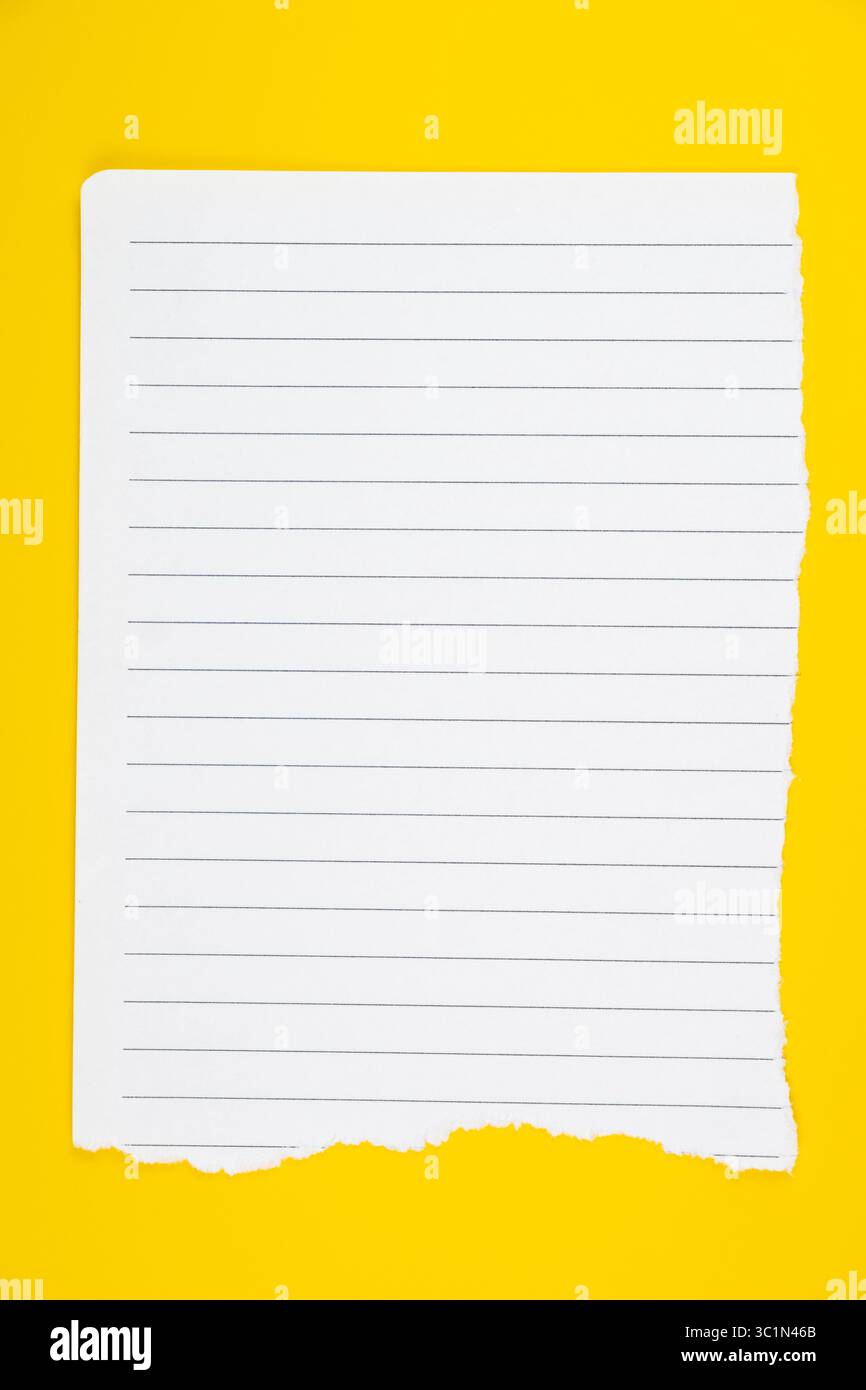 Weiß gestrichenes Papier, das unten auf leuchtendem gelbem Hintergrund gerissen wurde, um Notizen zu machen, zu schreiben oder zu Bildungszwecken zu machen Stockfoto