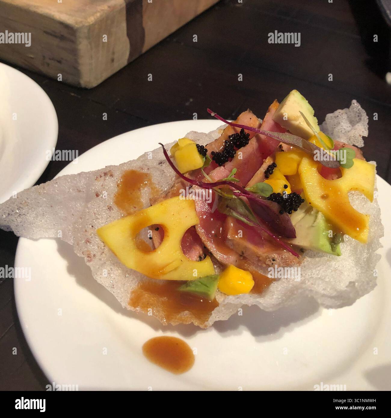 4. März 2019 – Orlando, Florida, USA – Tuna Tataki ist eines der neuen kulinarischen Angebote beim Epcot Flower and Garden Festival, das am 6. März eröffnet wird. Mit einem papierdünnen Reismehl Pappadam Crisp als Basis enthält er seltenen Thunfisch, der in würziger Zitrus-Yuzu-Glasur mariniert ist, mit Mango, Avocado, einem Stück eingelegter Lotuswurzel und Kaviar. Gefunden in der neuen Citrus Blossom Outdoor Küche in Showcase Plaza. .Foto: Sharon Kennedy Wynne (Foto: © Sharon Kennedy Wynne/Tampa Bay Times via ZUMA Wire) Stockfoto