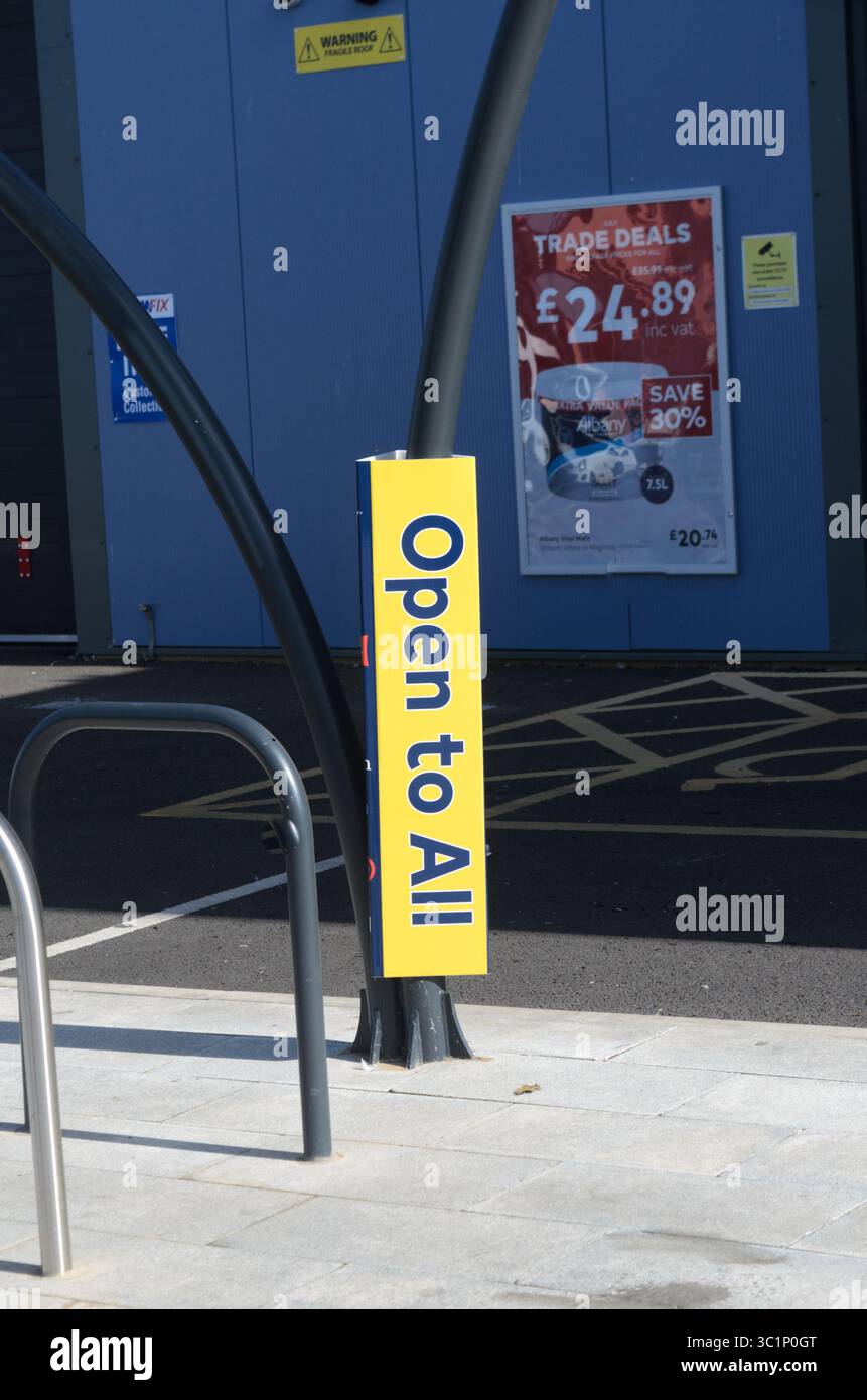 Ein vertikales Schild in Gelb mit dem Aufdruck „offen für alle außerhalb eines Geschäfts/Geschäfts in Großbritannien“ Stockfoto