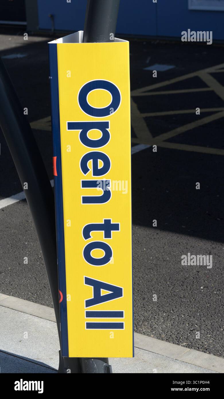 Ein vertikales Schild in Gelb mit dem Aufdruck „offen für alle außerhalb eines Geschäfts/Geschäfts in Großbritannien“ Stockfoto