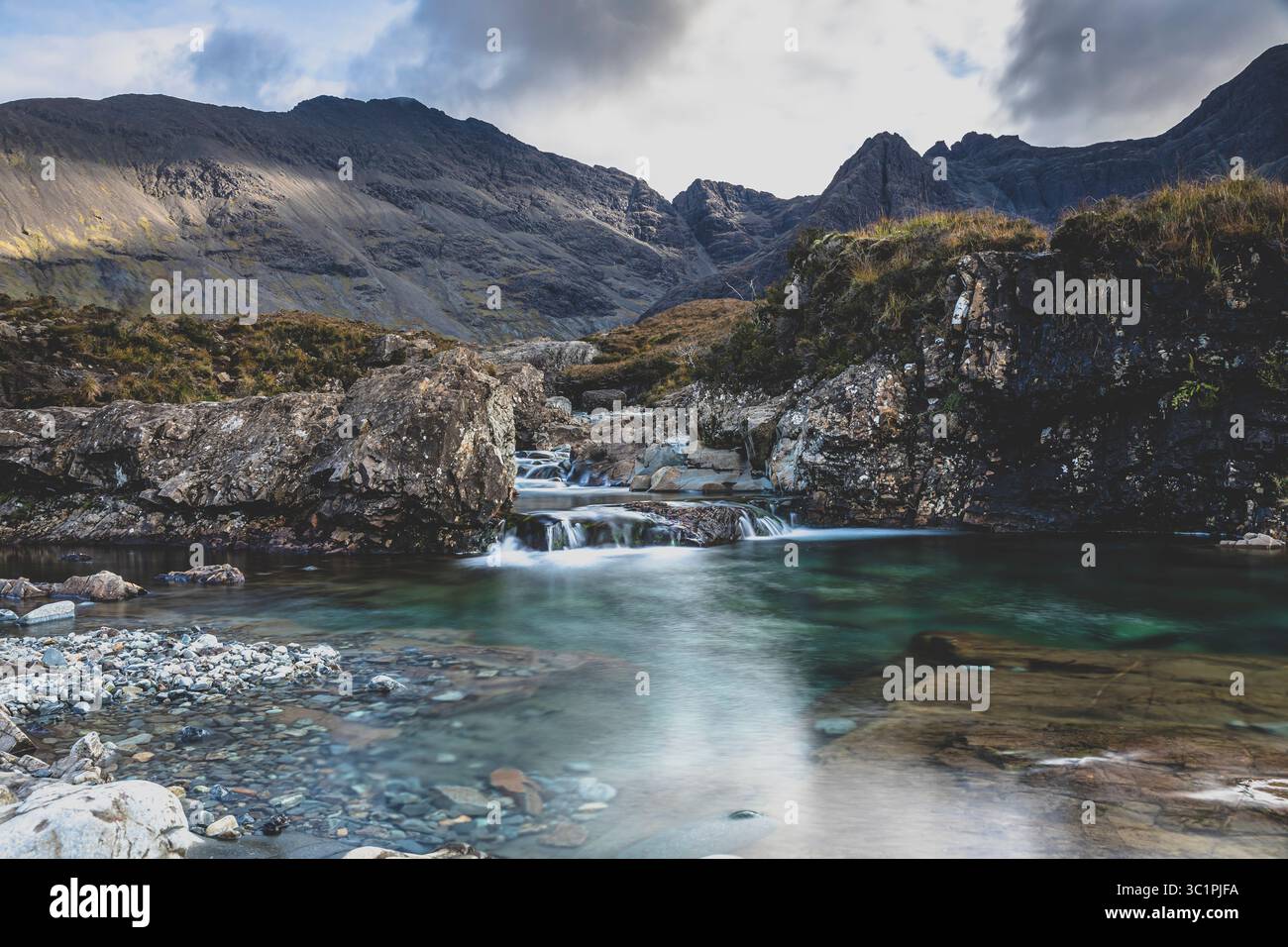 Die Feen-Pools auf der Isle of Skye mit kristallklarem Wasser und die Cuillin-Berge im Hintergrund, die mit einer langen Belichtung für einen seidigen ef aufgenommen wurden Stockfoto Die Feen-Pools auf der Isle of Skye mit kristallklarem Wasser und die Cuillin-Berge im Hintergrund, die mit einer langen Belichtung für einen seidigen ef aufgenommen wurden Stockfoto
