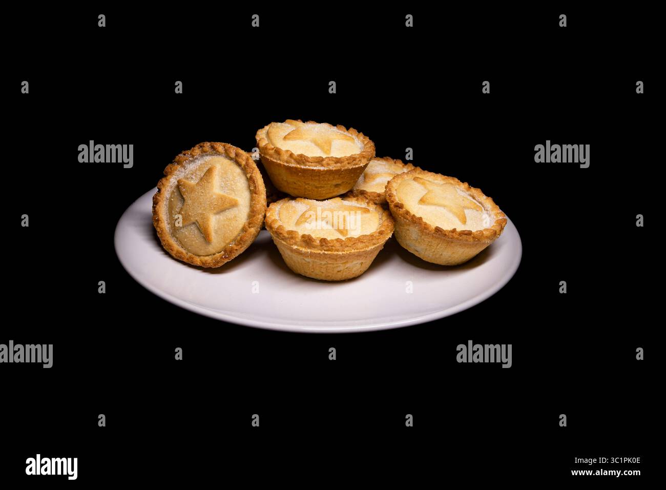 Mini-Hackkuchen auf einem Teller, schwarzer Hintergrund, schön und sauber. Im Grunde Weihnachten in einer kontrollierten Umgebung. Das ist genau die Art von Sache Stockfoto