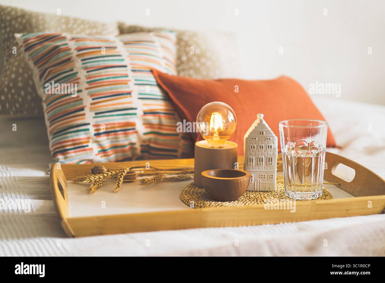 Leinenkissen auf einem weißen Bett mit Inneneinrichtung. Stilleben-Details zu Hause auf einem Bett. Gemütliches Zuhause. Stockfoto