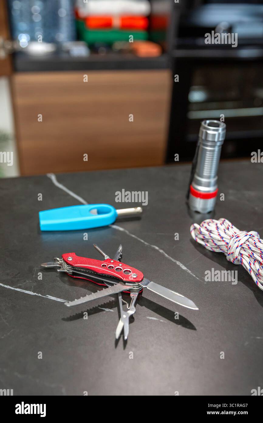 Überlebensvorräte auf der Küchentheke mit Laterne, Seil und multitool-Messer. 72-Stunden-Notfallkit. Stockfoto
