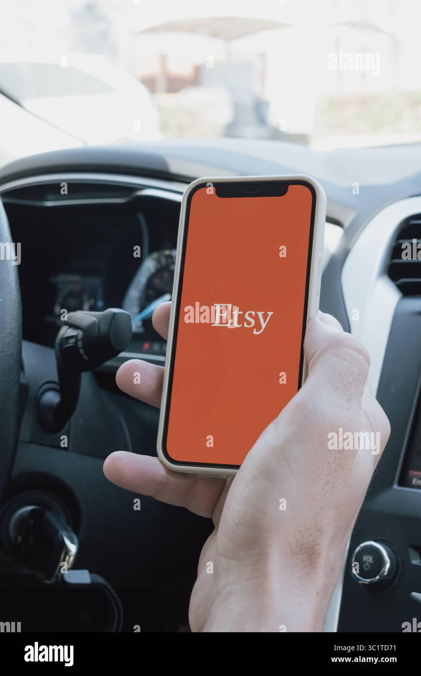 Rethymno, Griechenland. Juli 2025. Die Hand eines Mannes in einem Auto hält ein Telefon mit geöffneter Etsy-App Stockfoto